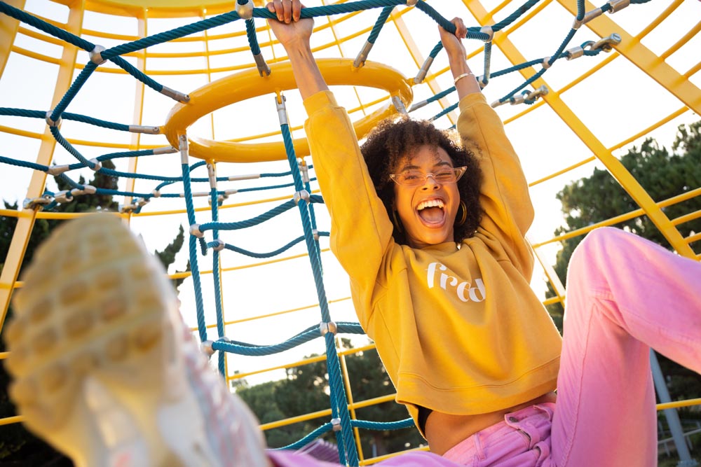 Young woman playing on jungle gym