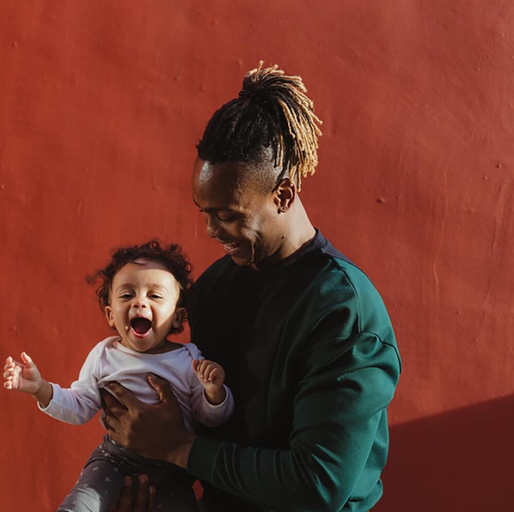 A smiling man holding a happy child